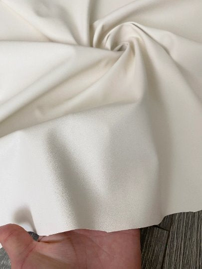 off white stretch Faux Leather, white faux leather, shiny faux leather, bright white faux leather for woman, faux leather for costumes, faux leather for home decor, 2 way stretch faux leather, leather for blazers, cheap leather, discounted leather, leather on sale