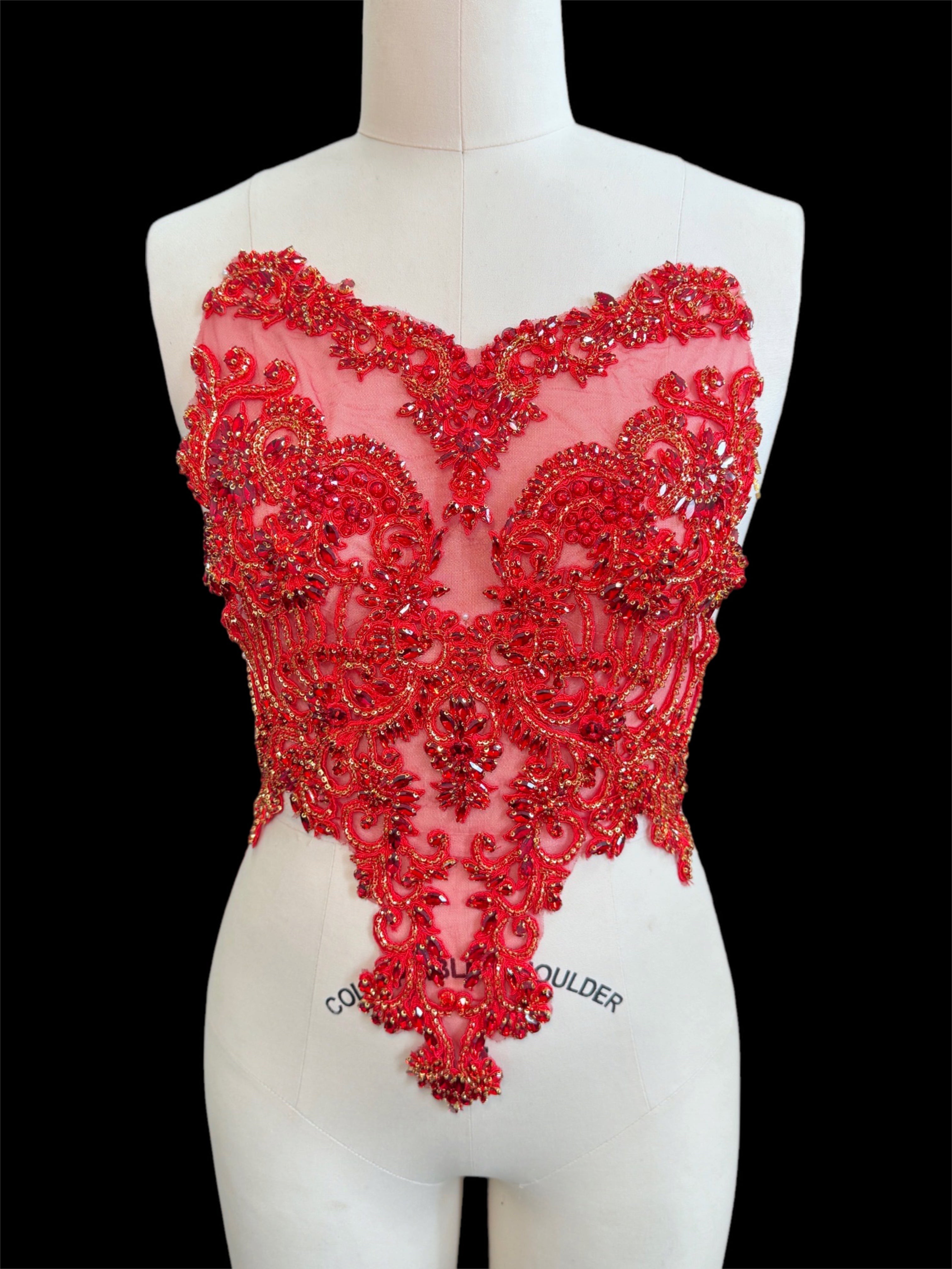 Red beaded top on a mannequin with a black background