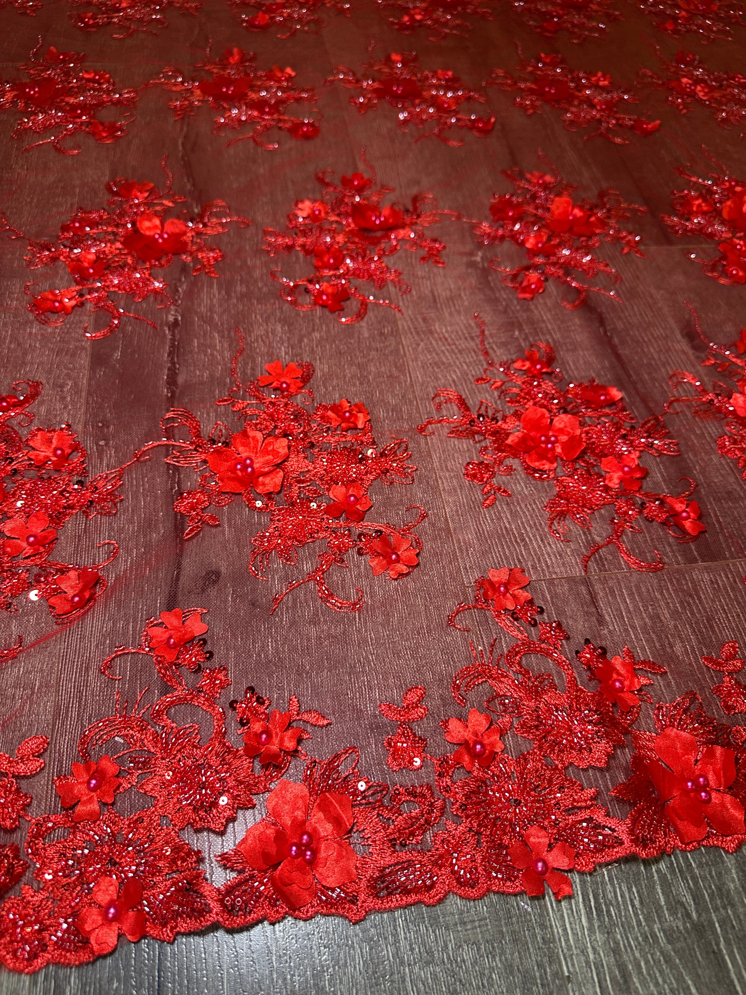 Red floral lace fabric on a wooden surface