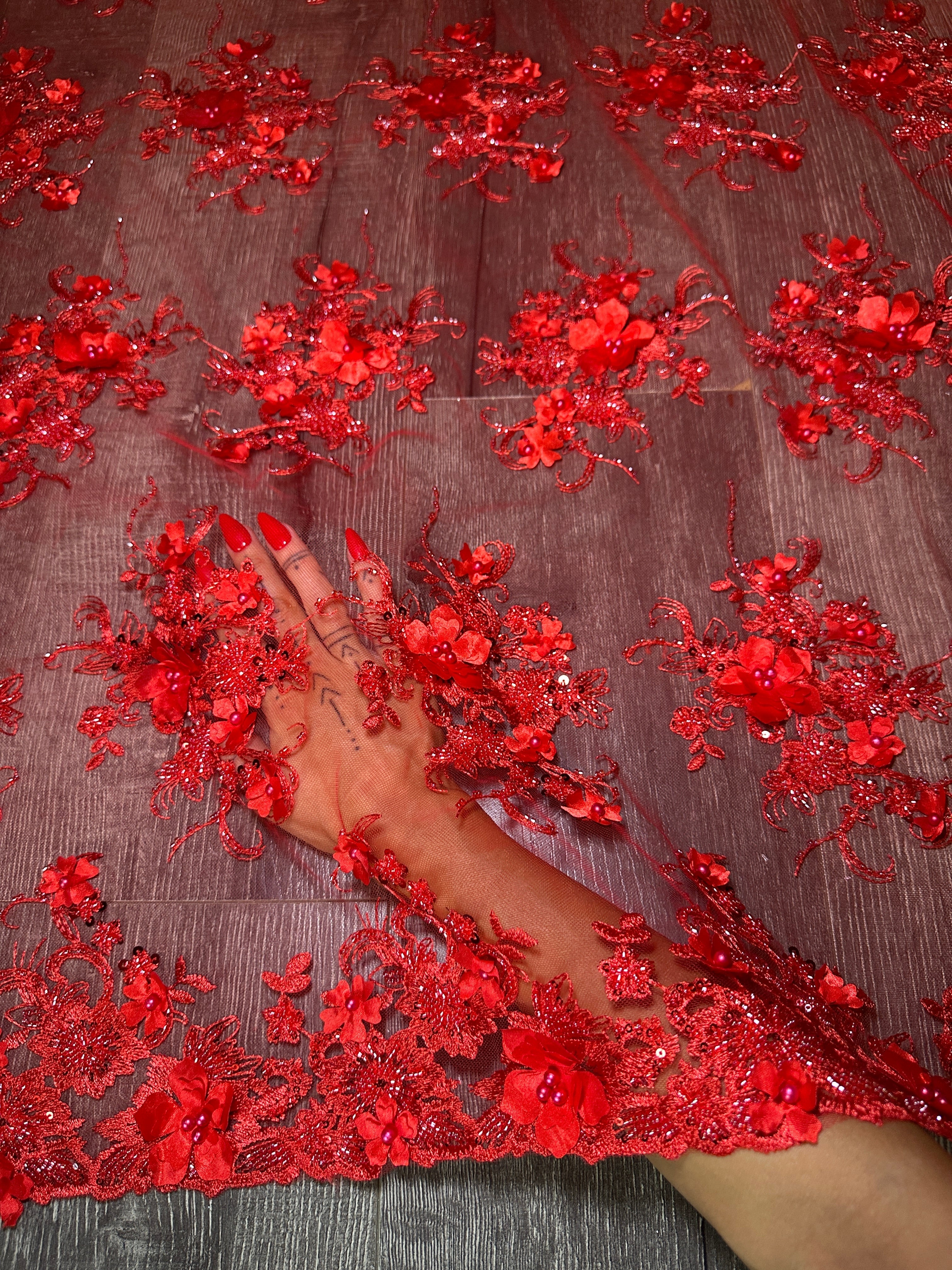 Red floral embroidery on a fabric surface