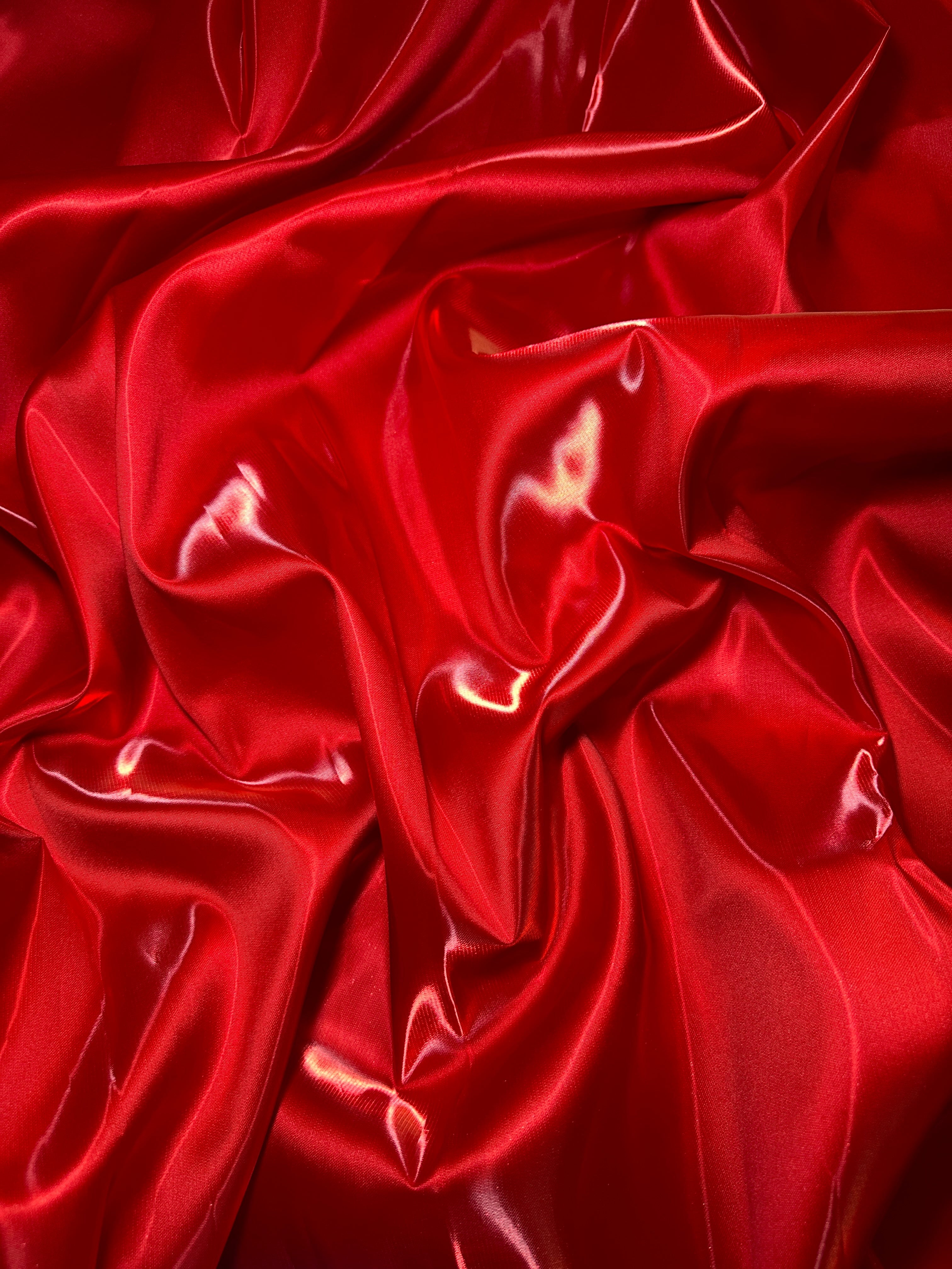 Close-up of red satin fabric with folds