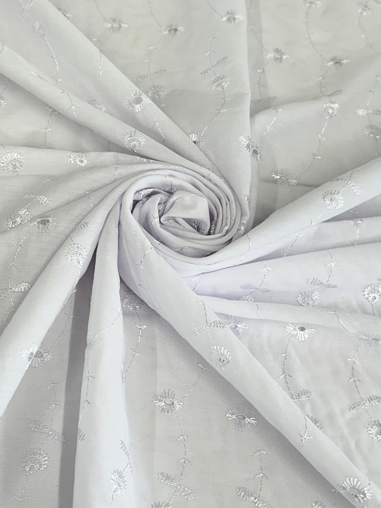rolled in flower shape white dainty cotton with embroidery of pattern in white 
