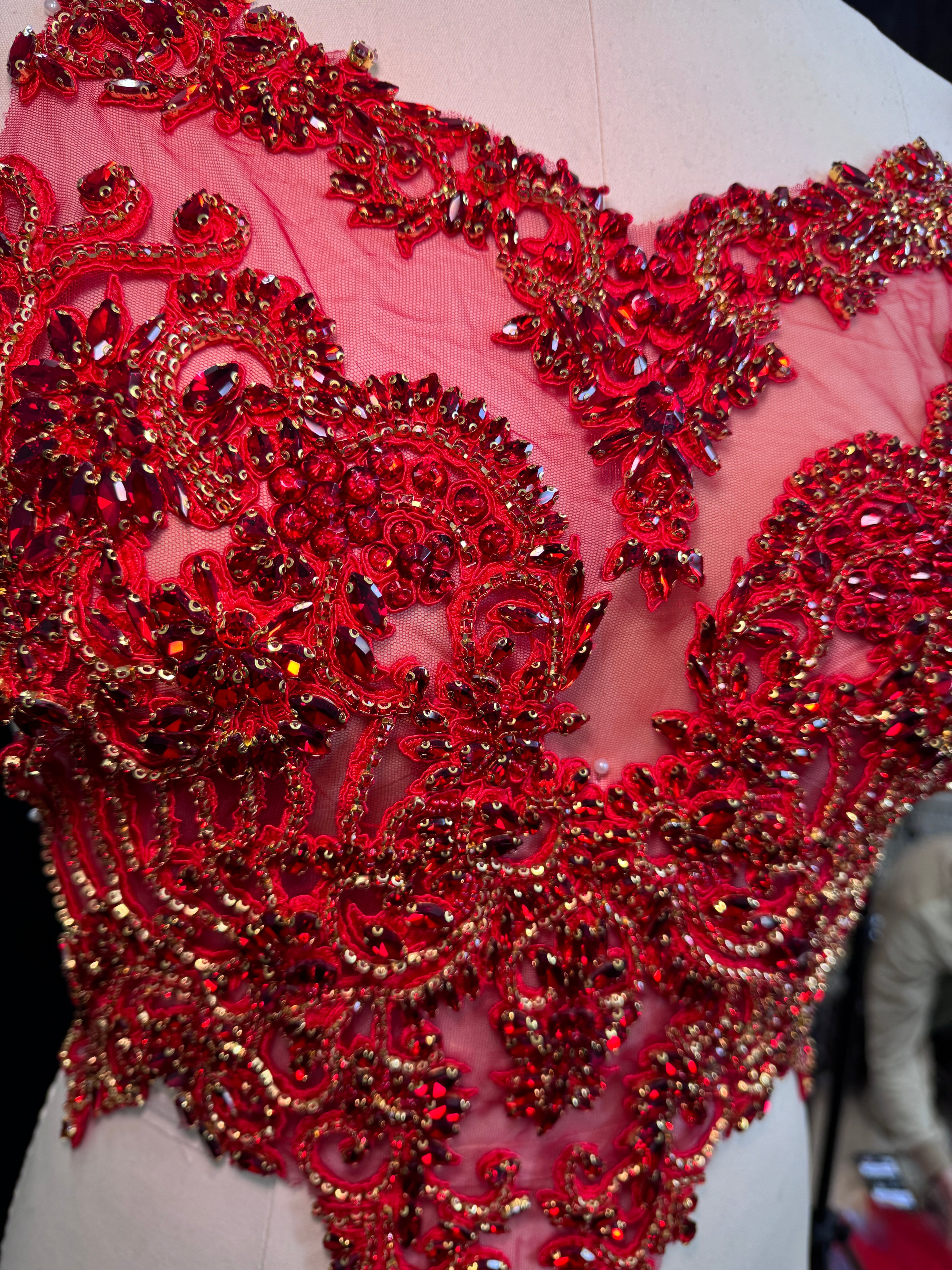 detailed  red beaded embellishment on red sheer fabric 