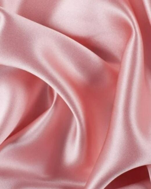 Close-up of pink satin fabric with folds