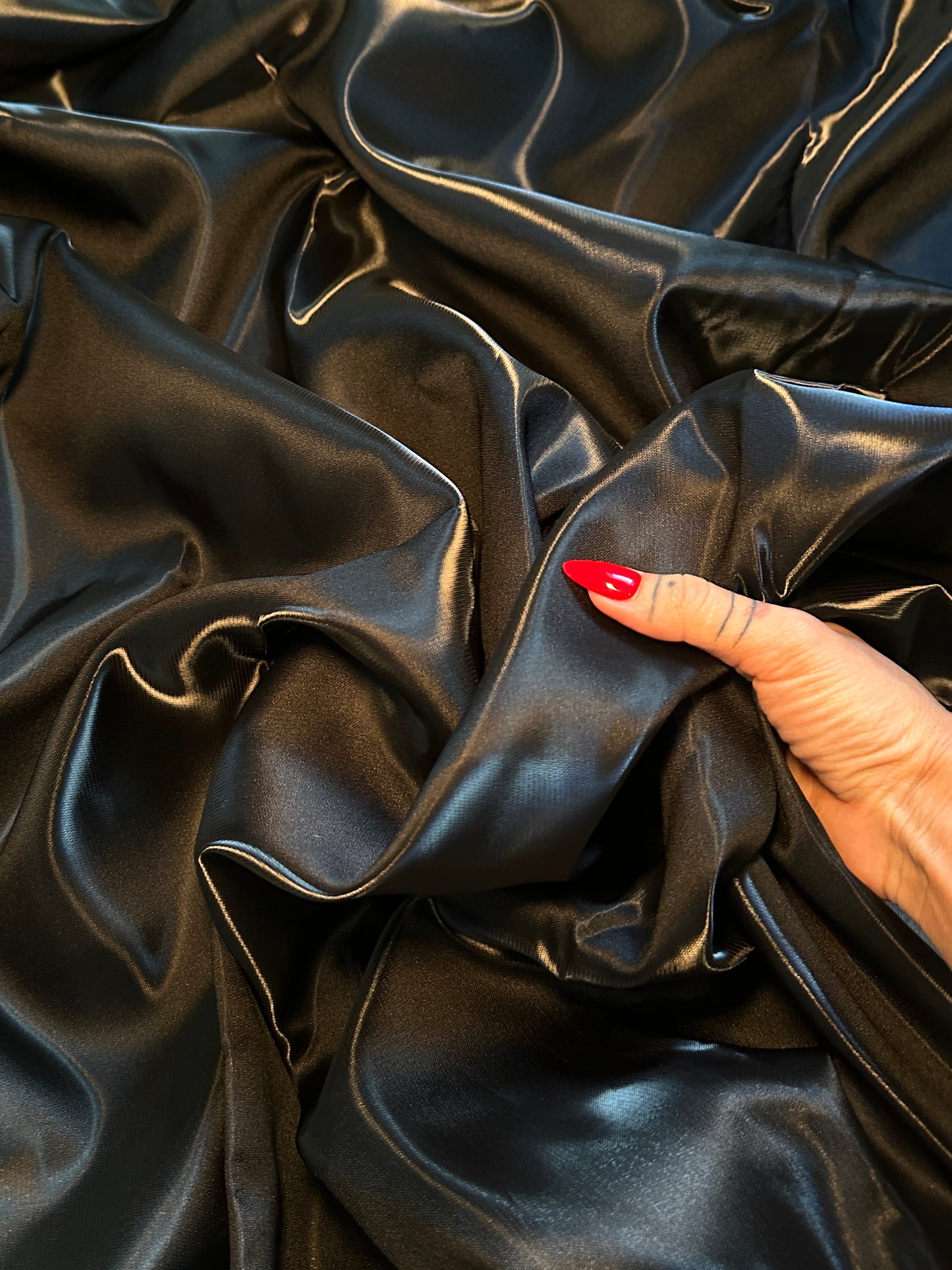 closeup look of liquid bridal satin in black for texture feel 