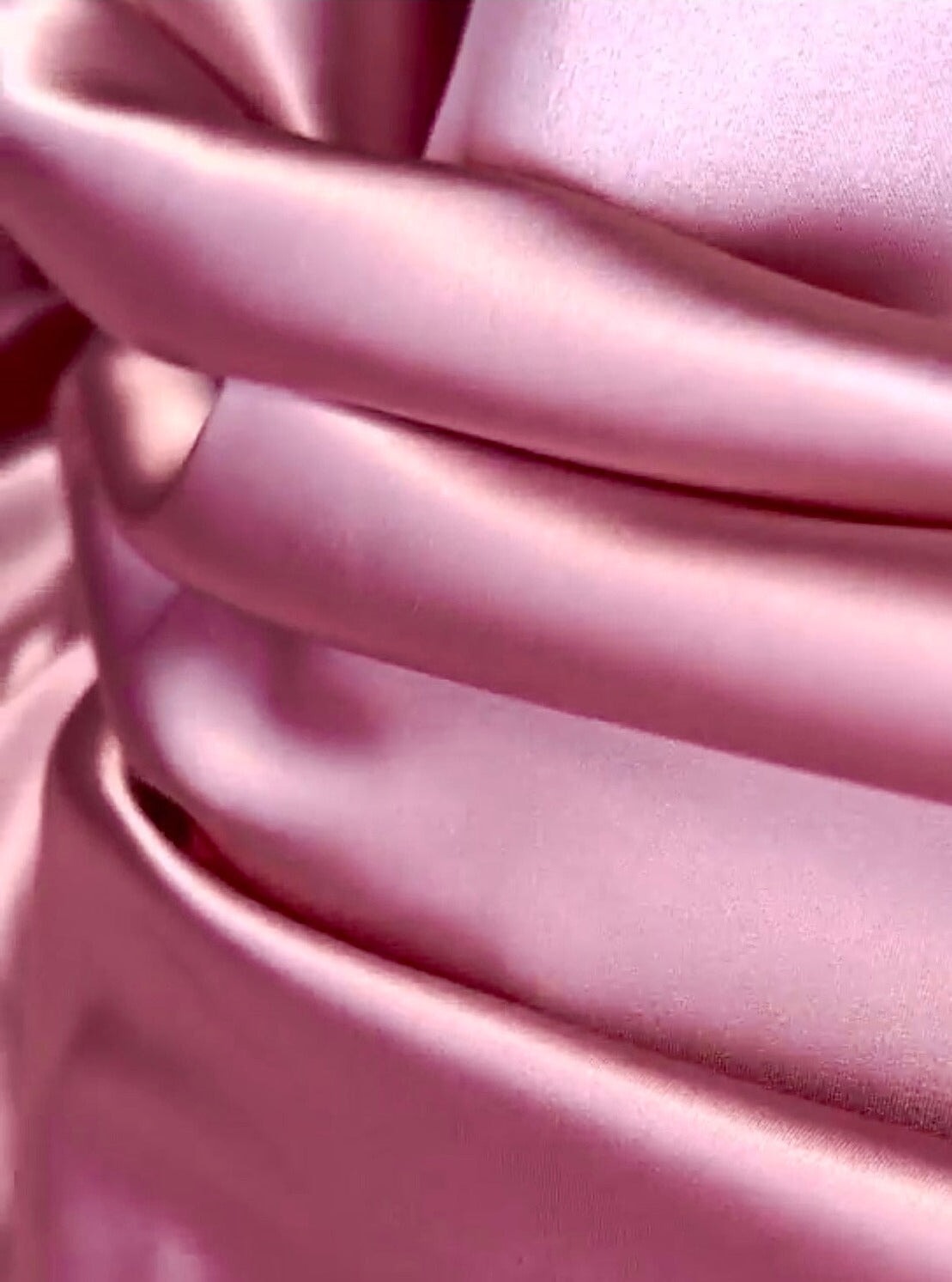 three round fold of pink shiny satin fabric 