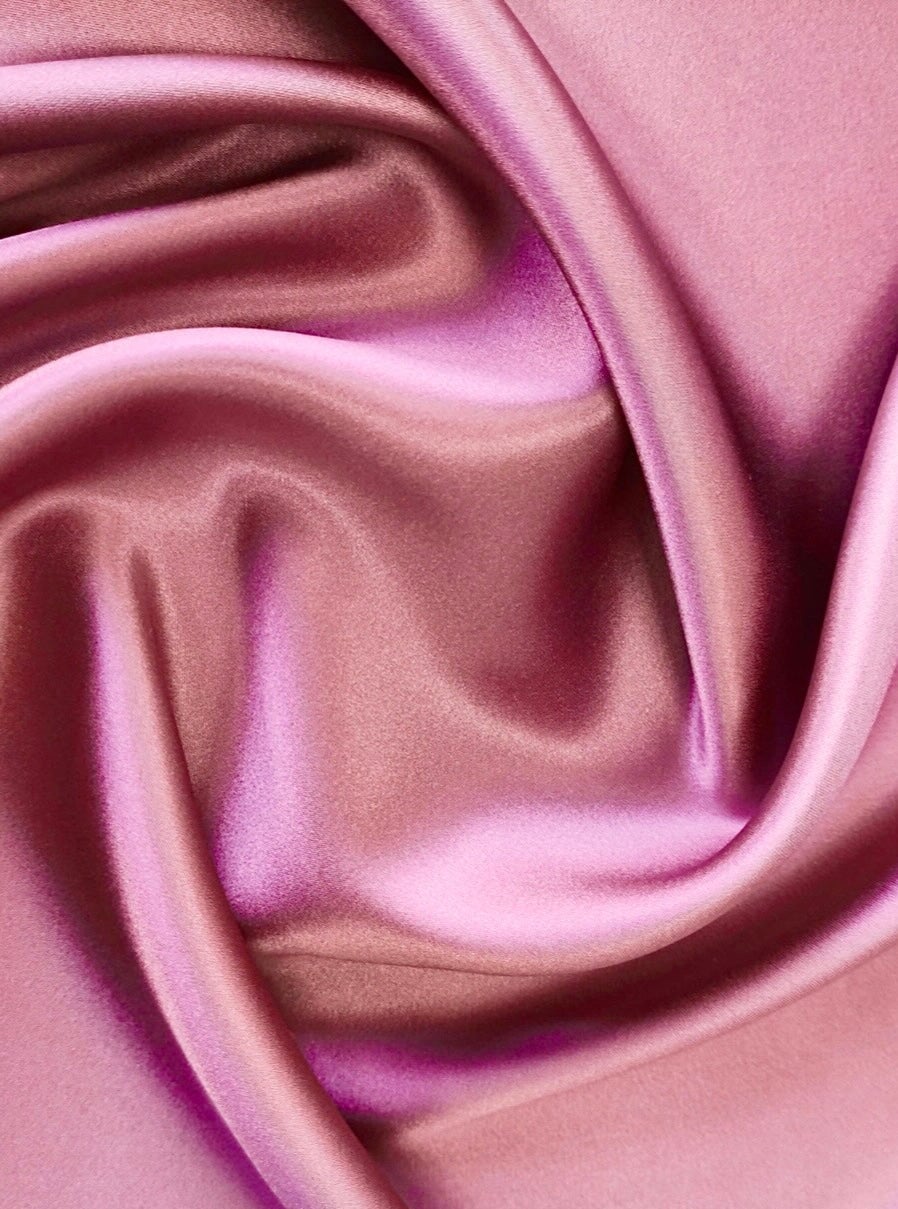 Close-up of pink satin fabric with folds
