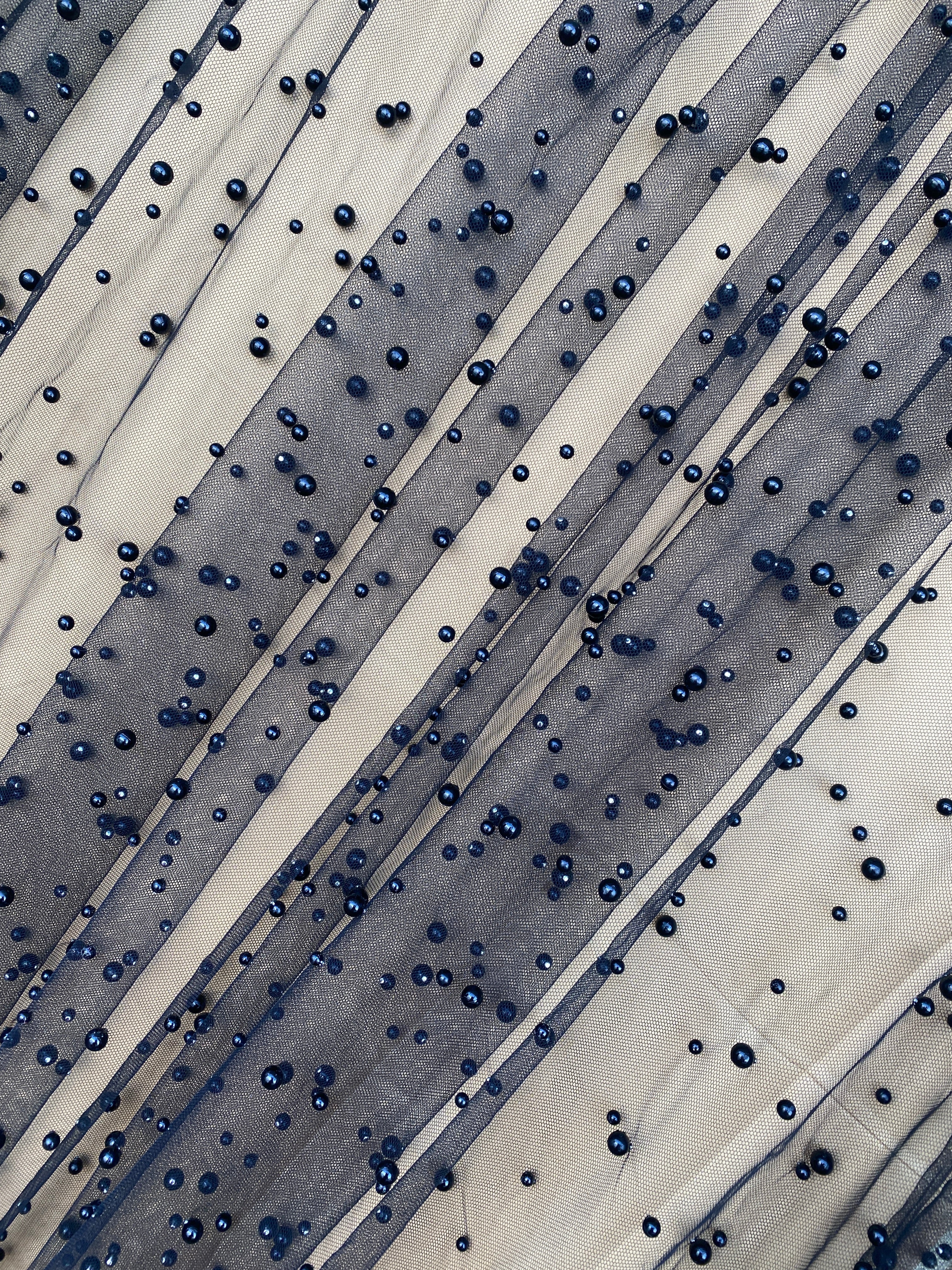 sheer fabric with beads above the white background 