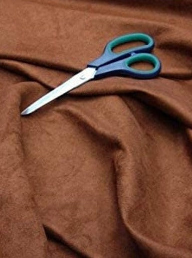 A scissors on brown microsuede fabric 
