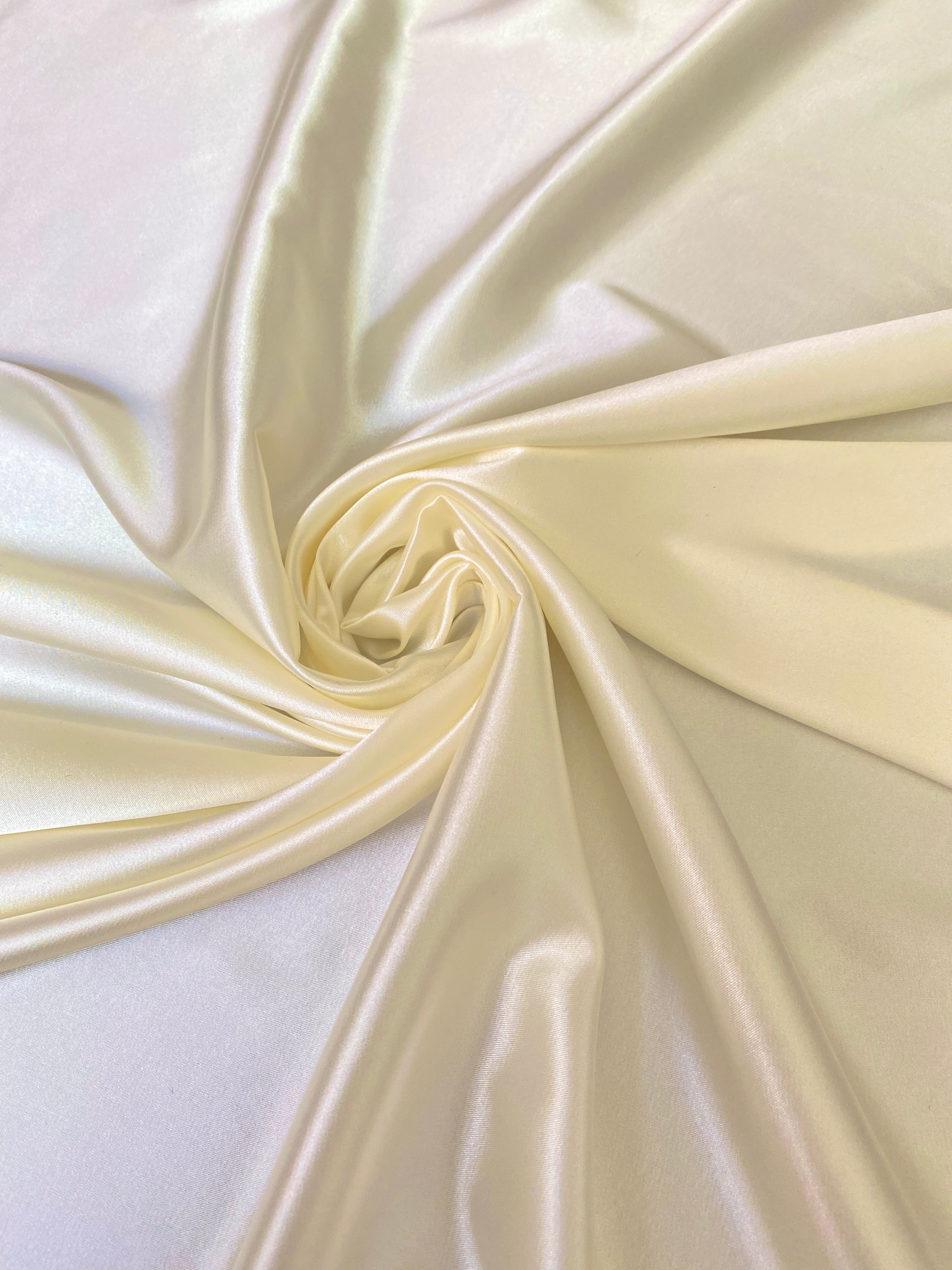 roll in flower display of ivory silky stretch satin fabric by the yard 